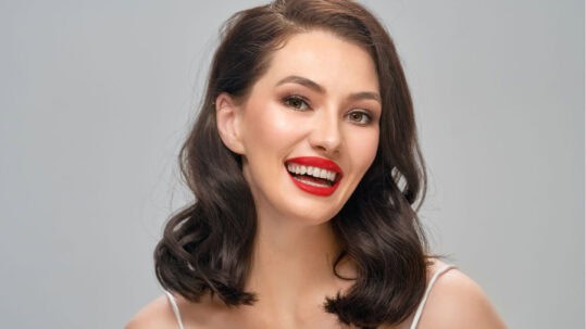 A young woman shows off her new smile after having a Smile Makeover.